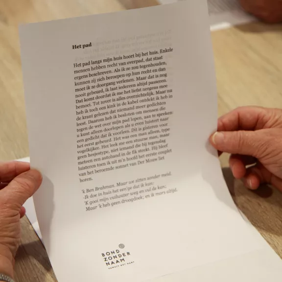 handen houden een blad met tekst vast