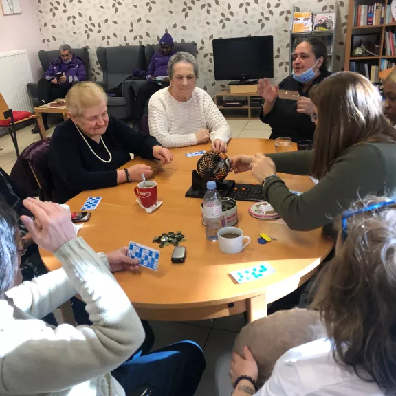 Mensen die samen aan een ronde tafel zitten en bingo spelen