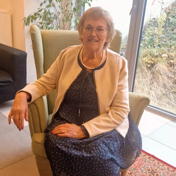 Een foto van een vrouw die op een zetelstoel zit