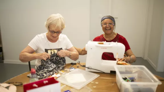Vrouwen amuseren zich achter de stikmachine.