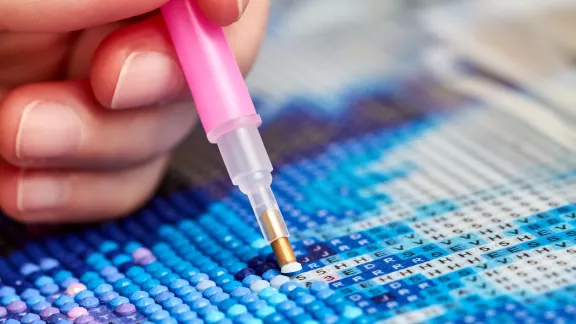 persoon maakt schilderij met de techniek dimond painting
