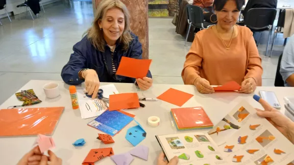 Vrouwen zitten aan een tafel een maken een knipwerk
