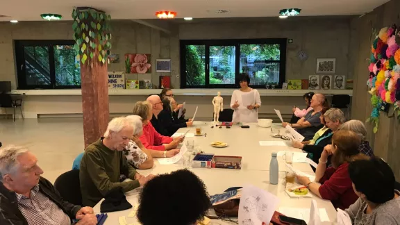 een groep personen volgt een infosessie