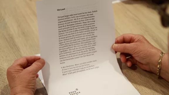 handen houden een blad met tekst vast