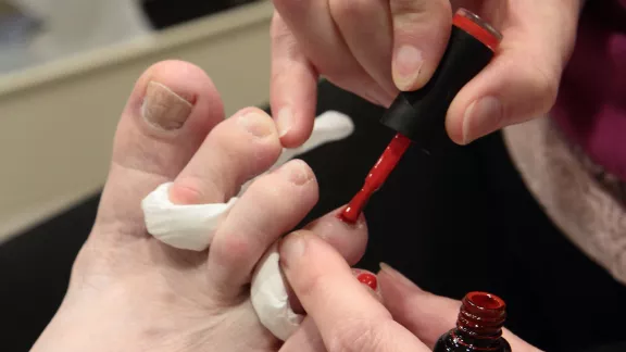 close-up foto van teennagels die rood gelakt worden 