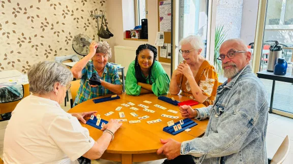 mensen zitten samen en spelen rummikub